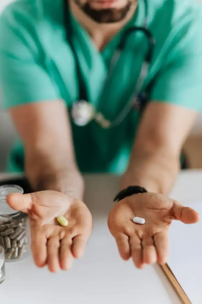 A doctor holds out two tablets, one in each hand as if giving a choice. It represents the selection of the right medicine for the exact problem. 