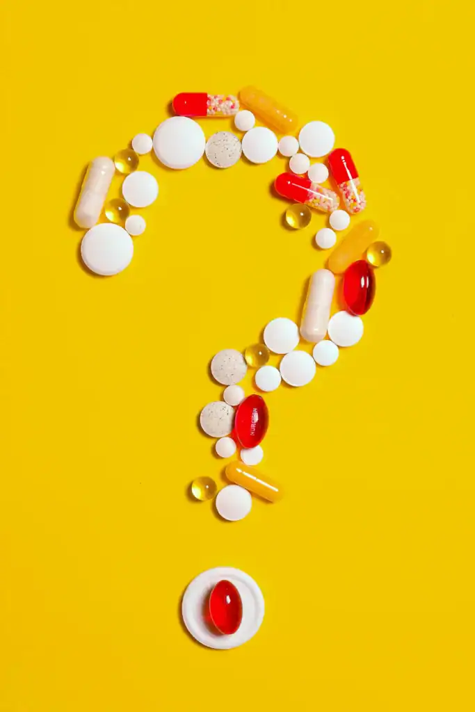 A collection of various pills and capsules are arranged into a question mark. It represents the quest to find which chemical compound could be the next big antibiotic