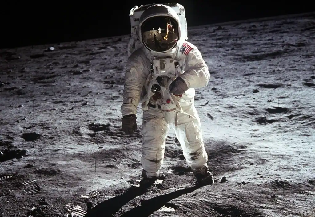 An Astronaut in a spacesuit stands on the surface of the moon. The image looks to a future in which humankind can do more than just walk on the moon. 