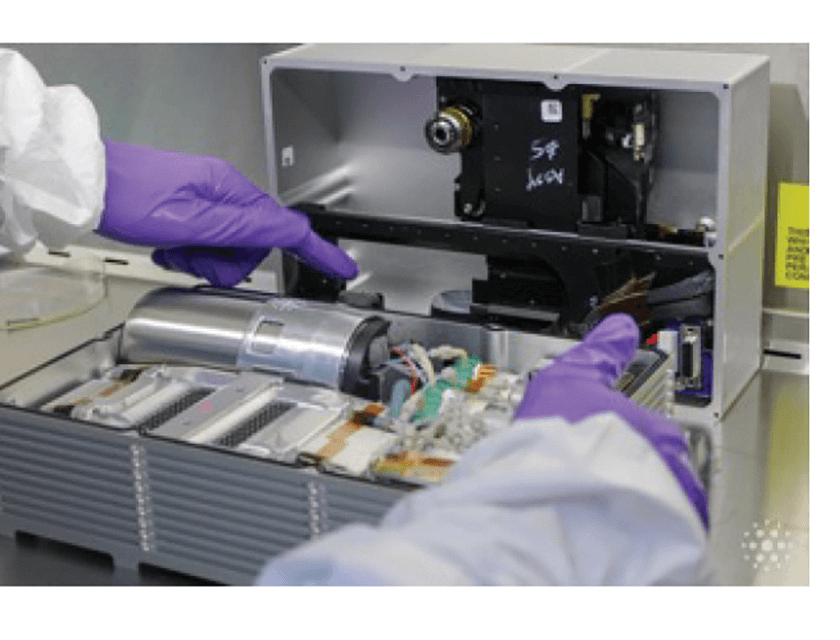 An image of the equipment the scientists used to monitor the cells. Someone wearing a white coat and purple lab gloves is operating it.